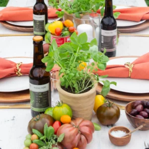 Tomatoes and basil in terracotta pots as table decorations for an Italian party