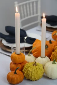 Orange und weiße Kürbisse als herbstliche Kerzenständer