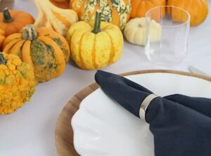 Blaue Leinenservietten und gebe Kürbisse auf einem Herbsttisch