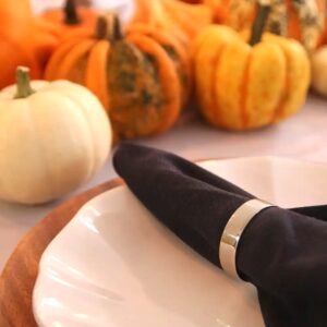 Leinenservietten und silberne Serviettenhalter auf einem herbstlichen Tisch