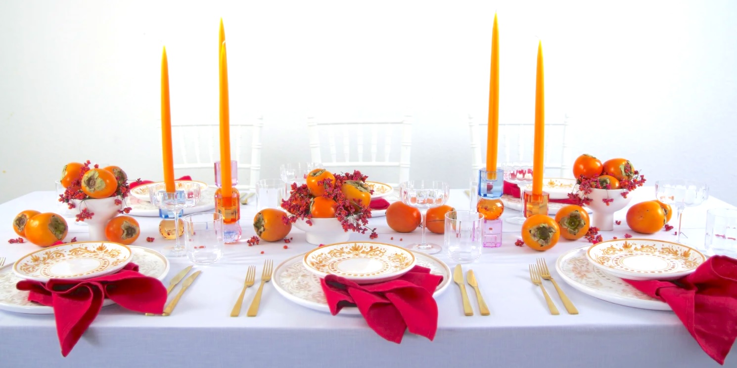magnolias-on-silk-january-table-of-the-month-kaki-persimone-1 banner Table decoration with persimmon and red accents on a white tablecloth.