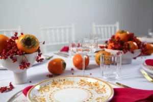 YOKI vase with persimmon and red berries, embedded in a maximalist table decoration.