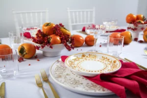 Gold-decorated plate from the Adelasia collection with red napkin and glasses from the Jazz collection.