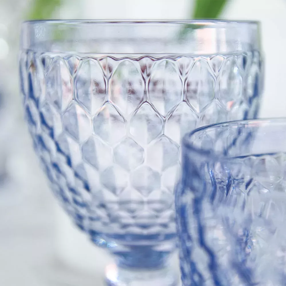 magnolias-on-silk-table-of-the-month-mai-peony-red-blue-table-inspiration-14-square Close-up of the Villeroy & Boch glasses from the Boston blue series, stylishly staged with a floral blur in the background.