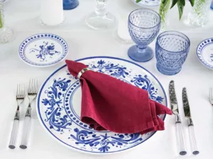 Table decoration with deep red peonies, blue glasses from Villeroy & Boch and blue and white crockery