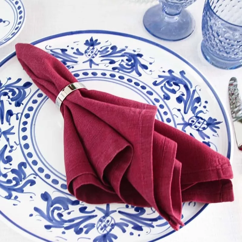 magnolias-on-silk-table-of-the-month-mai-peony-red-blue-table-inspiration-16-square Close-up of a red linen napkin on a blue and white Adelasia Blu plate.