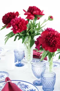 Table decoration with peonies, Villeroy & Boch glasses and place plates in blue