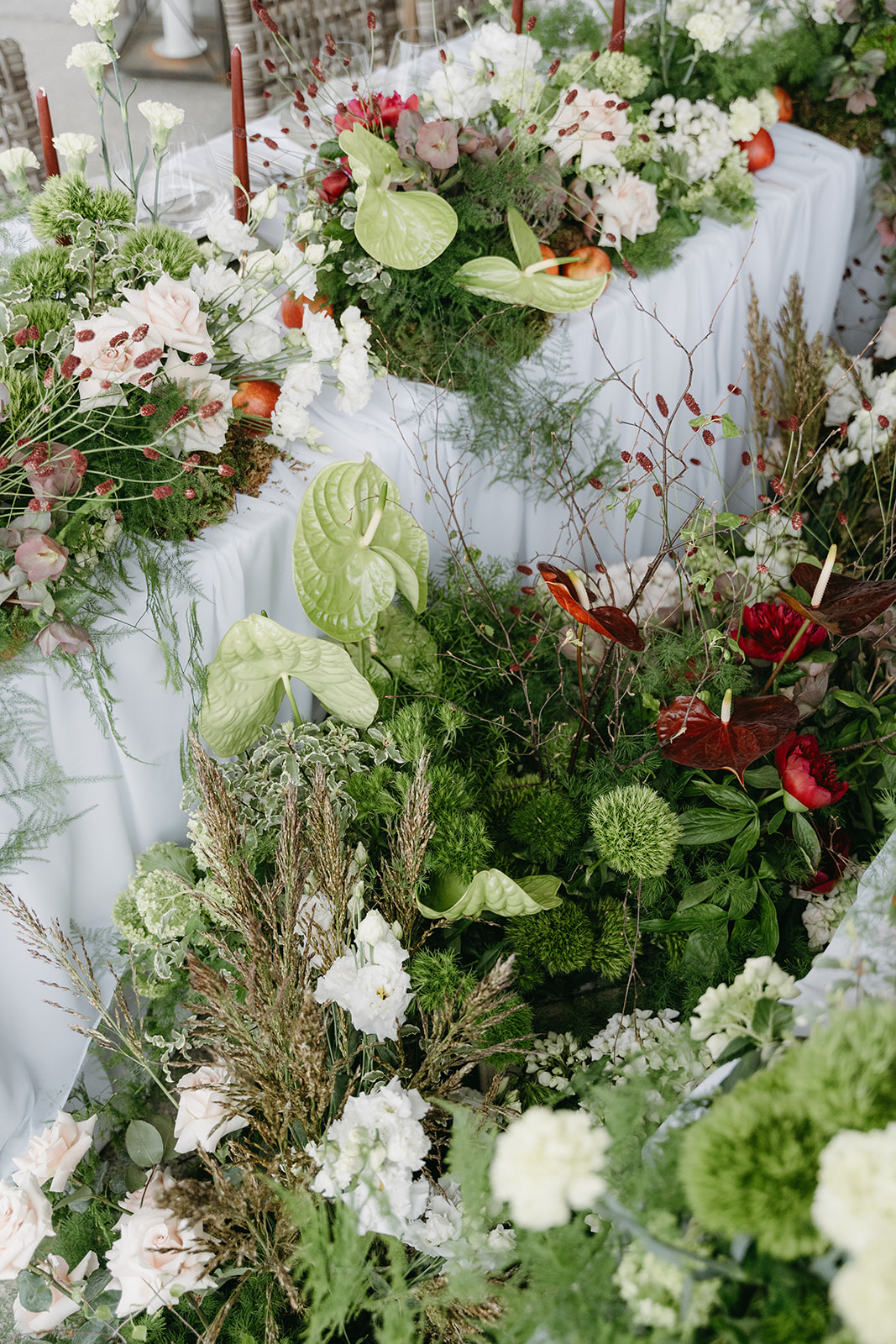 Spatial floral installation in Meadow style with white, green and rose-coloured flowers, grasses and textured greenery - part of a Nature Reimagined table design.