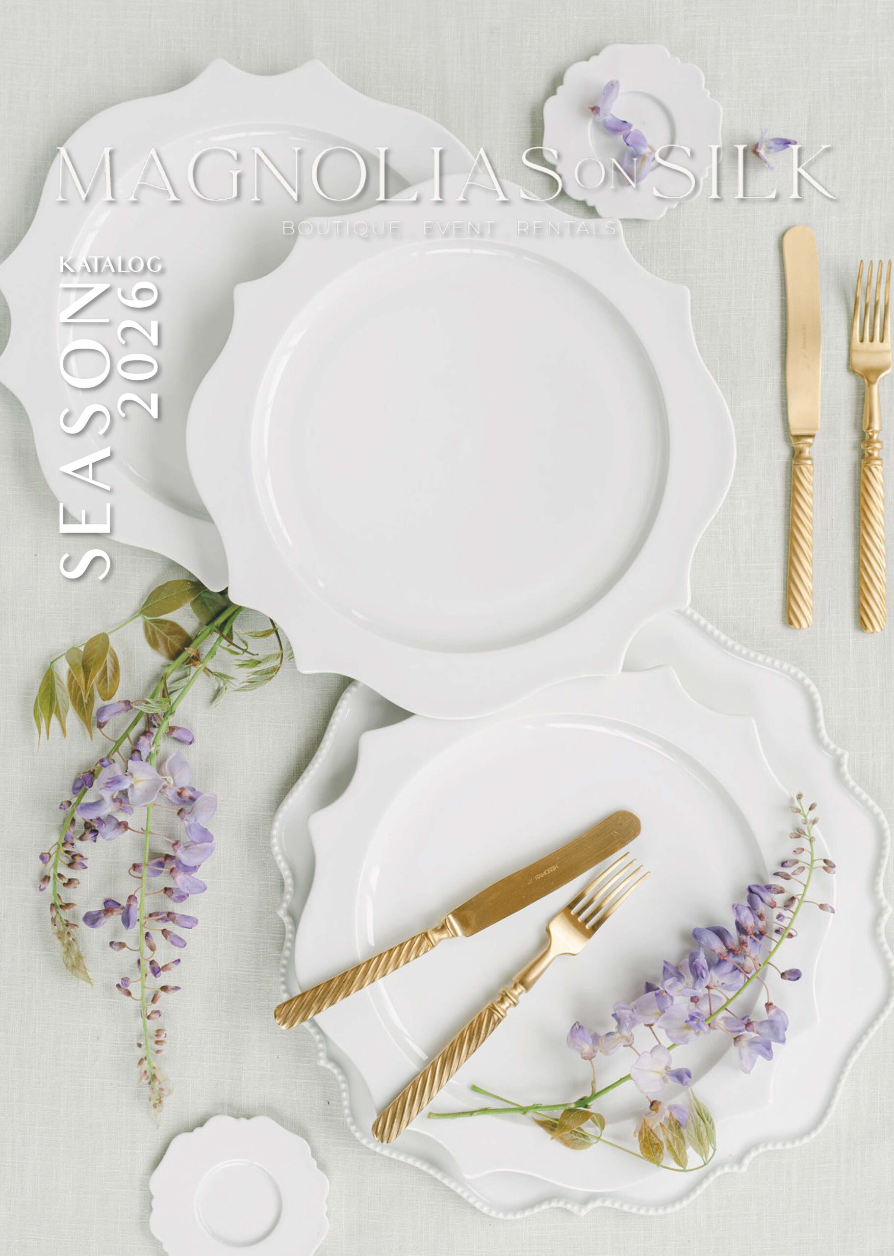 Elegantly laid table with white porcelain, gold-coloured cutlery and floral accents - Magnolias on Silk